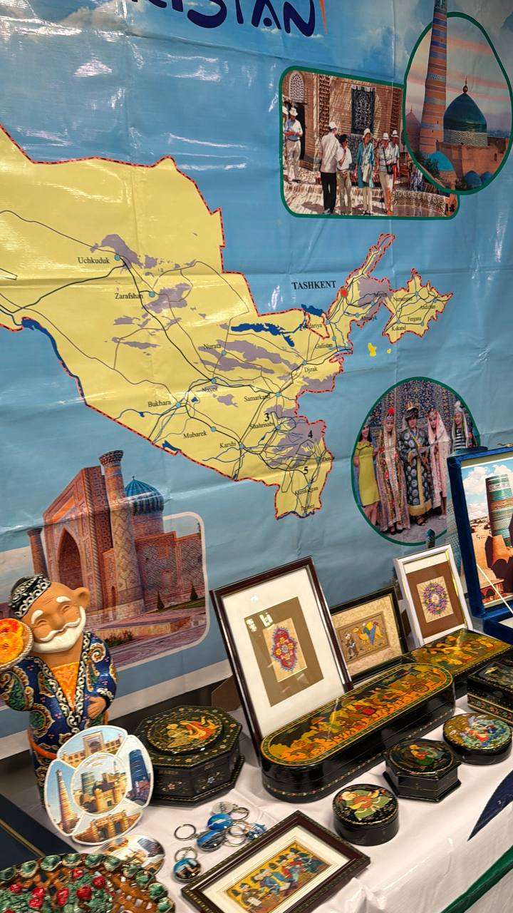 Display of crafts and photographs arranged beneath a map of Uzbekistan