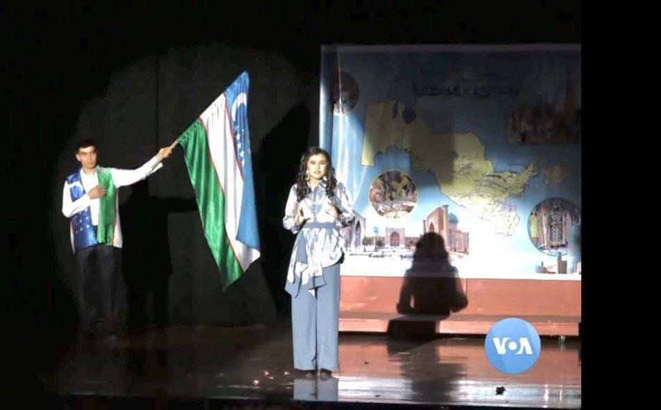 Theatrical performance beneath a projected map of Uzbekistan