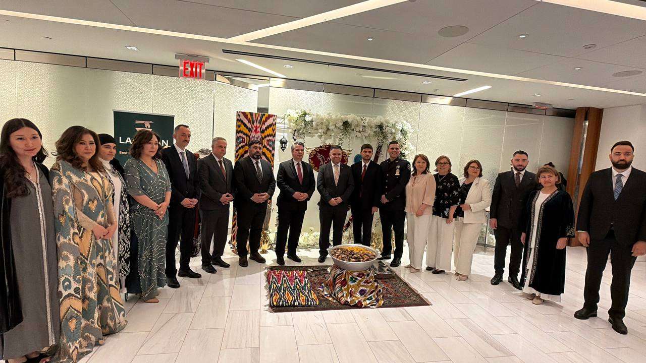 Attendees gathered in a hall decorated with carpets for a formal reception