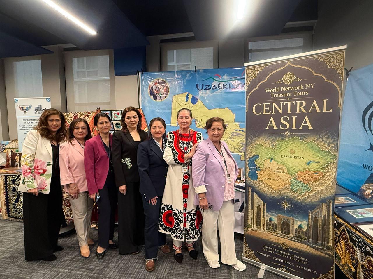 Group standing beside a Central Asia travel banner at a cultural showcase